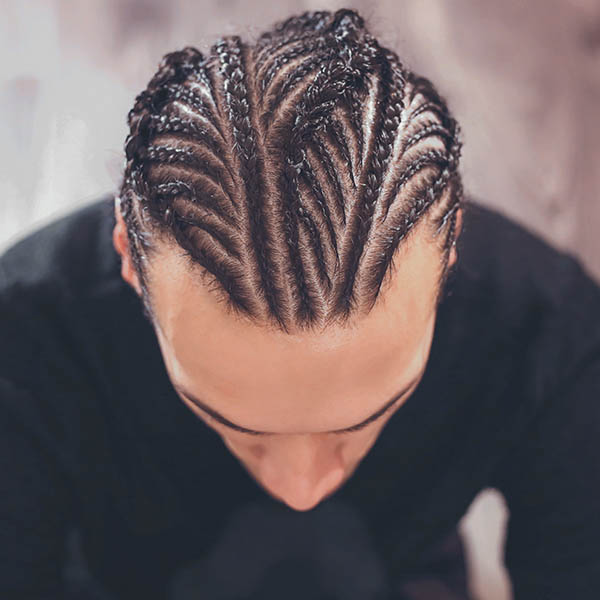 male hairstyle close-up braids, hair braided, pensive look, man portrait