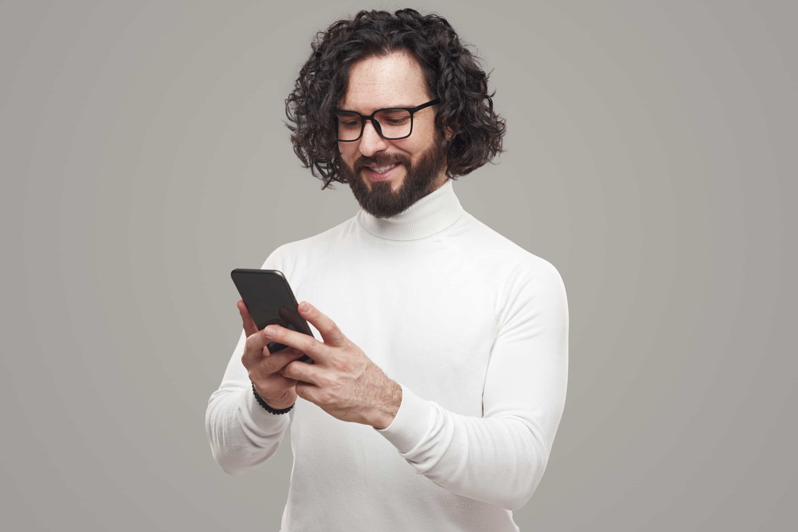 A long-haired man booking a barber shop appointment on his smartphone